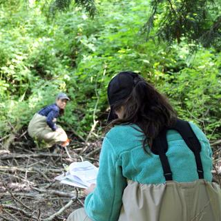 Roxanne Croxall and Ashley Van Acken run a transect through a wetland area.